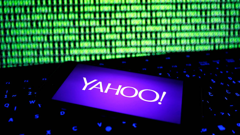 A photo illustration shows a Yahoo logo on smartphone in front of a displayed cyber code and keyboard