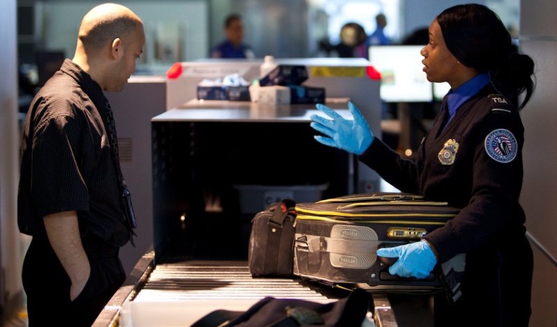 FILE PHOTO - A Transportation Security Administration (TSA) security agent takes a traveler's luggage for a second security check at John F. Kennedy Airport in New York, U.S. on February, 29, 2012.    REUTERS/Andrew Burton/File Photo