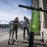 People use a smartphone to LimeBike shared electric scooters on the Embarcadero in San Francisco. MUST CREDIT: Bloomberg photo by David Paul Morris.