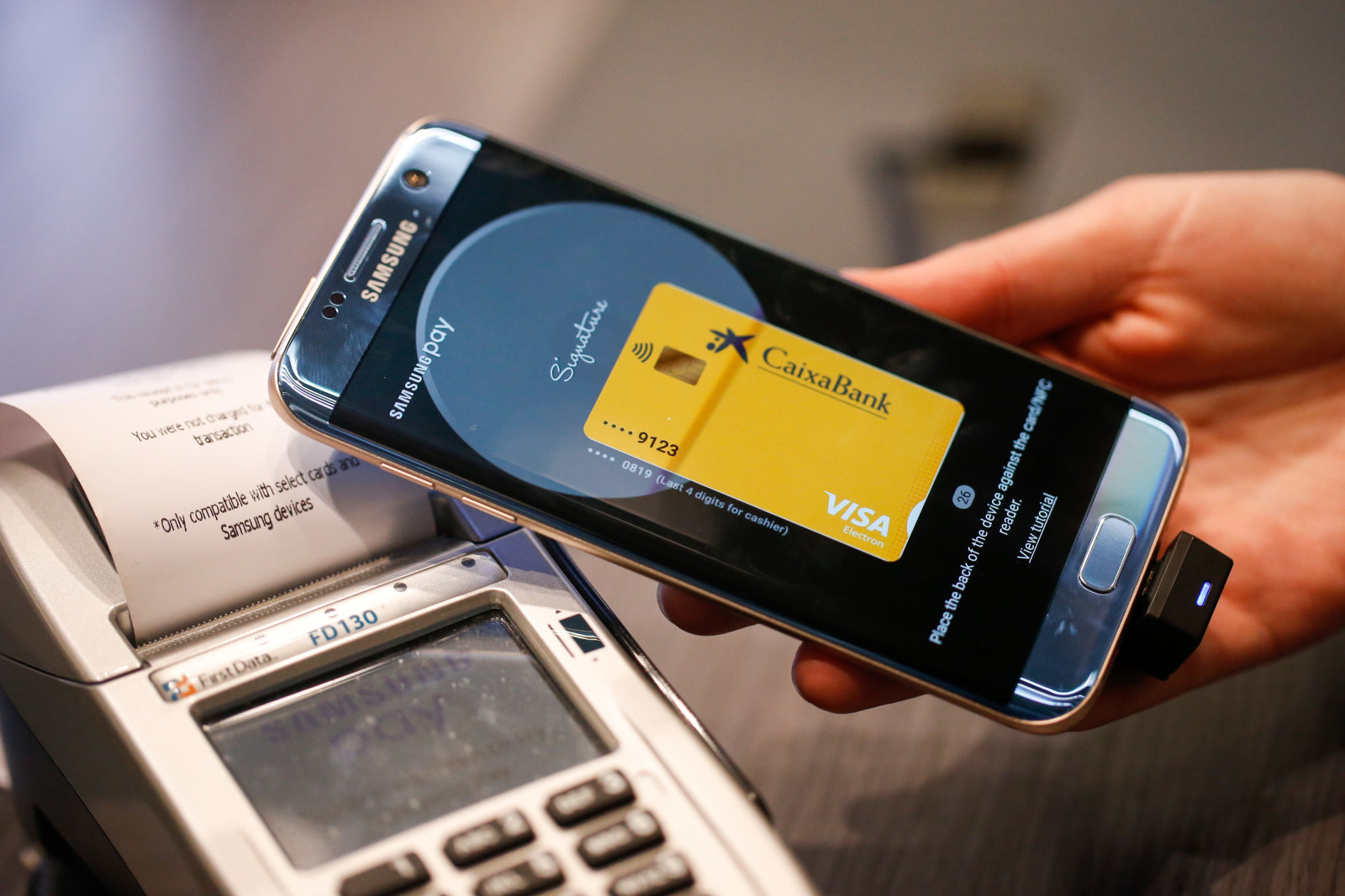 A worker demonstrates wireless payment using the Samsung Pay app on a Galaxy smartphone, manufactured by Samsung Electronics Co. Ltd., on the opening day of the Mobile World Congress (MWC) in Barcelona, Spain, on Monday, Feb. 27, 2017. A theme this year at the industry's annual get-together, which runs through March 2, is the Internet of Things. Photographer: Pau Barrena/Bloomberg via Getty Images