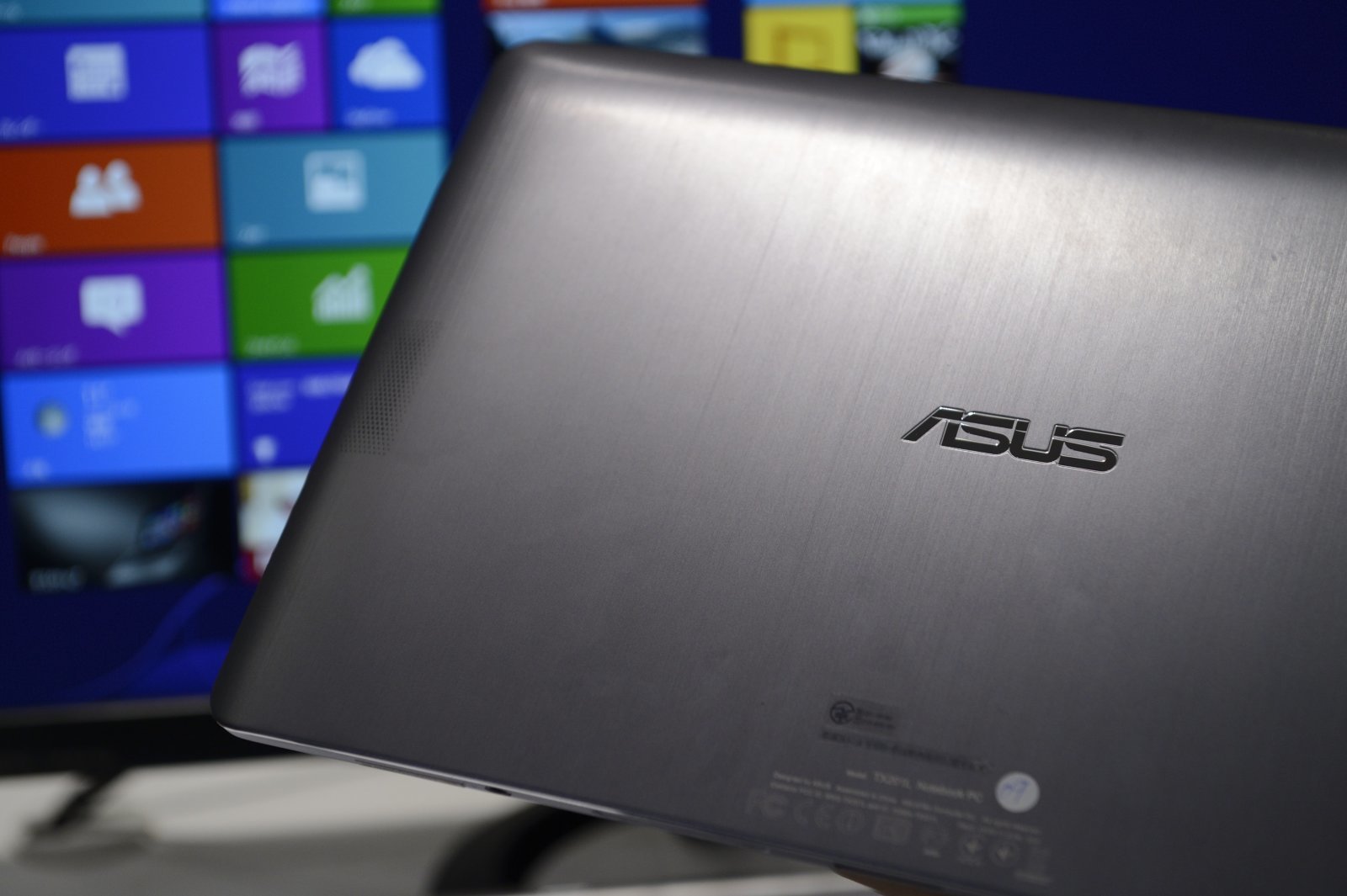 The Asus logo is displayed on the back of an Asus TransBook Trio TX201LA device, manufactured by Asustek Computer Inc., in an arranged photograph during a product unveiling in Tokyo, Japan, on Tuesday, Oct. 29, 2013. Asustek is working in its research and development facility to make a wearable device, Shih said. Photographer: Akio Kon/Bloomberg via Getty Images