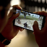 An Indian boy plays an online game PUBG on his mobile phone sitting outside his house  in Hyderabad, India, Friday, April 5, 2019. A boy’s suicide in India after his mother scolded him for playing the popular online game PlayerUnknown’s Battlegrounds has inflamed a debate across the country over whether the game should be banned. (AP Photo/ Mahesh Kumar A.)