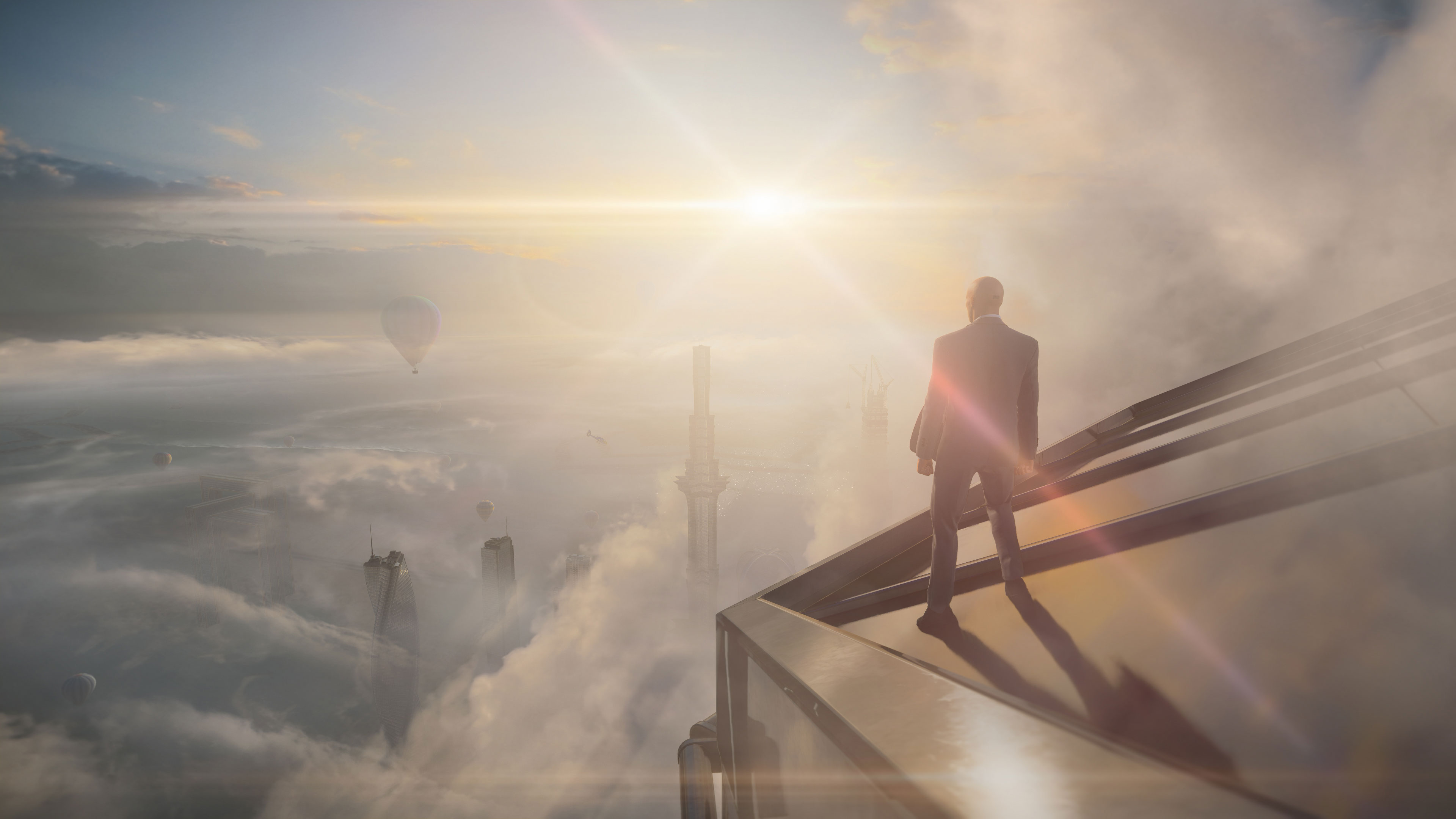 Agent 47 on top of a building overlooking the clouds