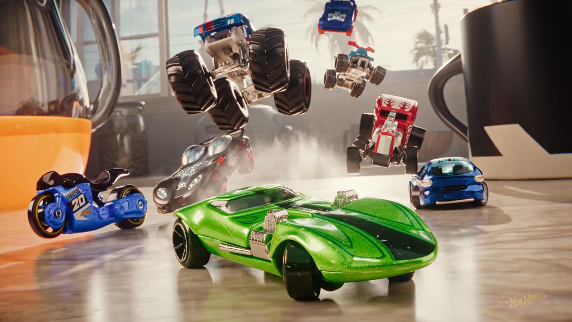 A group of cars and motorbikes speed across a kitchen countertop. They stream past a kettle and a mug, which appear giant next to the tiny vehicles